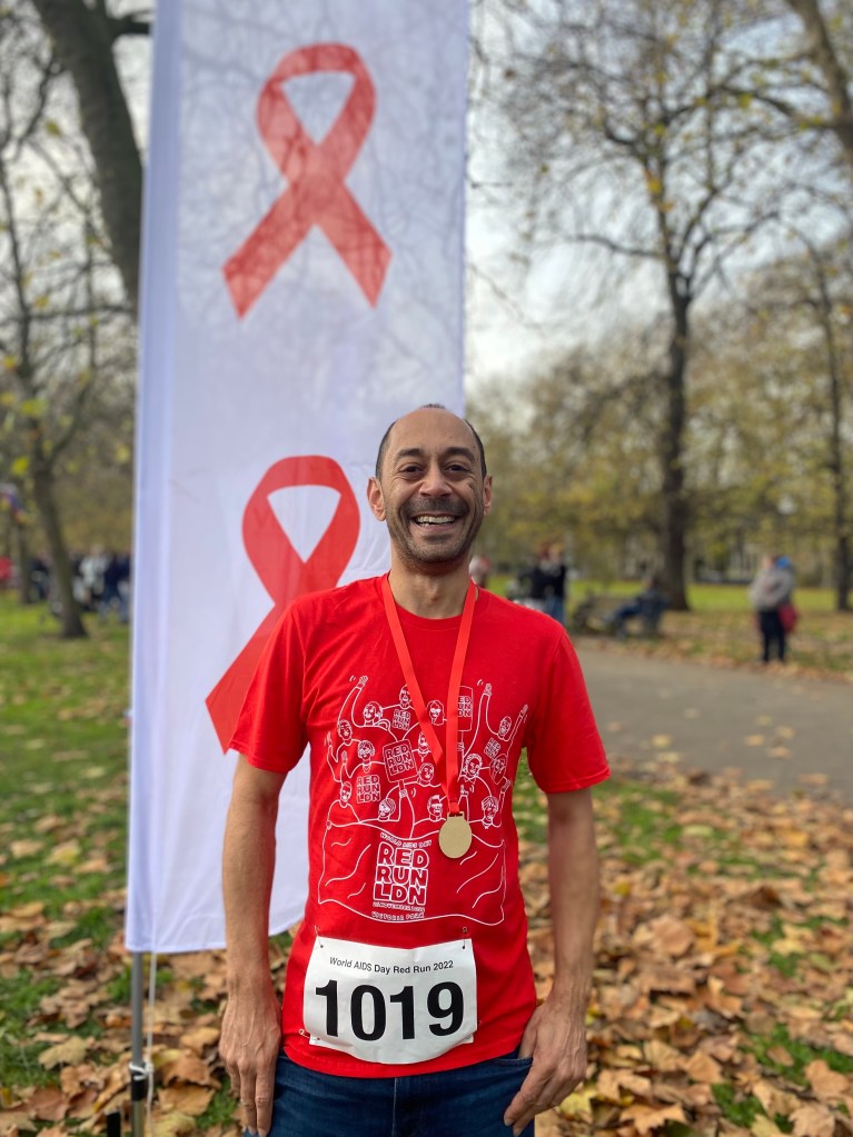 HIV activist Ant Babajee pictured wearing a red World AIDS Day t-shirt outside for the Red Run. 