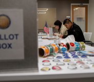 People sit at a table while others come in to vote during the US midterm elections