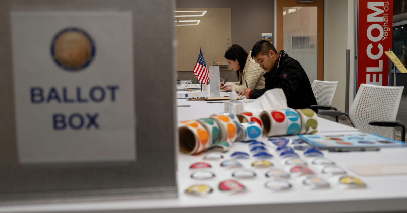 People sit at a table while others come in to vote during the US midterm elections