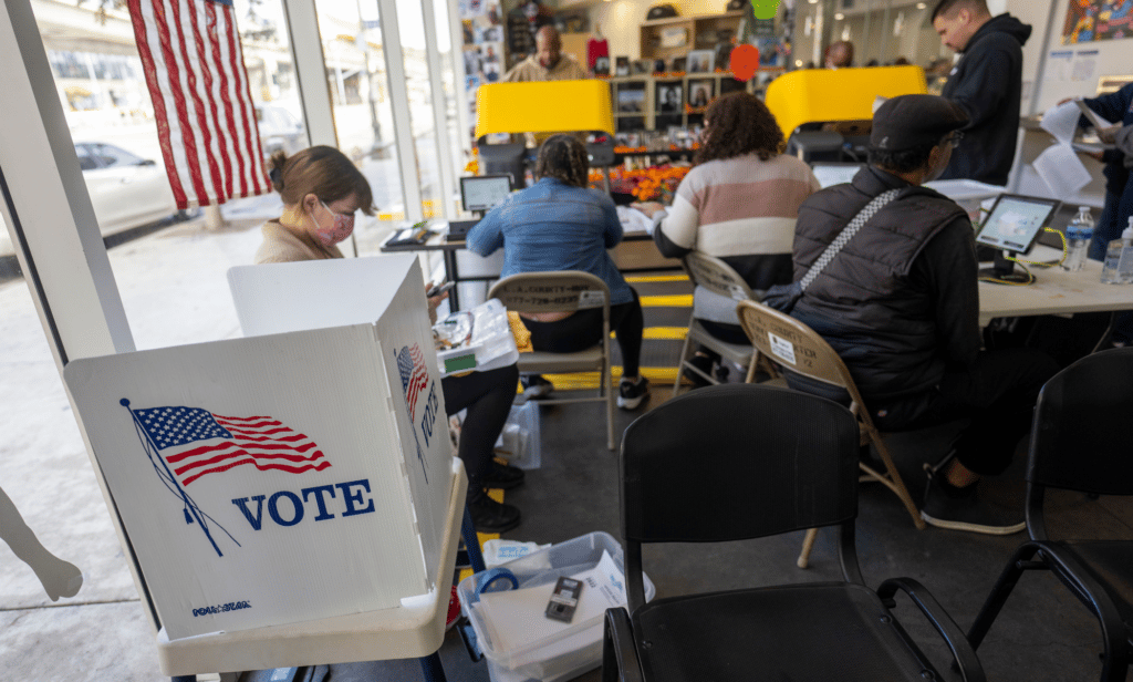 Several people gather in a building to cast their votes during the US midterm elections