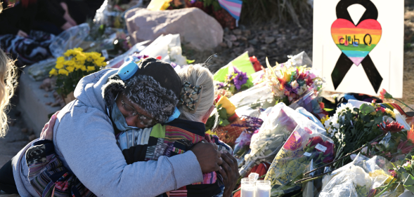 A person gets comforted by a friend at a makeshift memorial near Club Q on November 20, 2022 in Colorado Springs, Colorado. The venue was the scene of a mass shooting