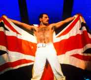 Freddie Mercury holding up a Union Jack on stage.