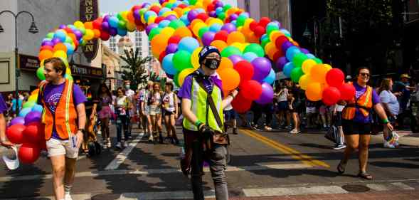 A group of people march with pride balloons in Nevada