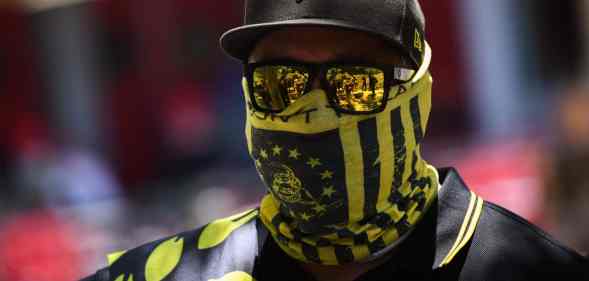 One of the members from the far-right group Proud Boys wearing a black and yellow bandana, cap and sunglasses