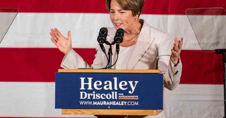 A photo of Democrat Maura Healey standing in front of the American flag as she talks into a microphone during her acceptance speech