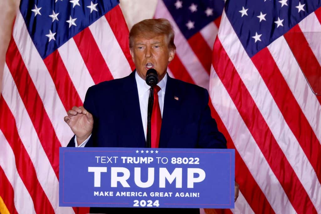 Former US President Donald Trump stands in front of American flags while he speaks at the Mar-a-Lago Club in Palm Beach, Florida.