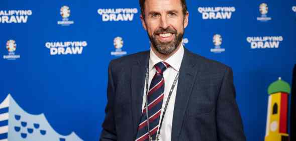 England manager Gareth Southgate wearing a navy coloured suit jacket and tie over a white shirt smiles to the camera at the UEFA Euro 2024 Qualifying Group Stage Draw - Ceremony