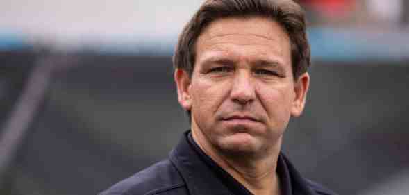 Florida Governor Ron DeSantis wearing a black shirt and jacket looks on before the start of a game between the Georgia Bulldogs and the Florida Gators
