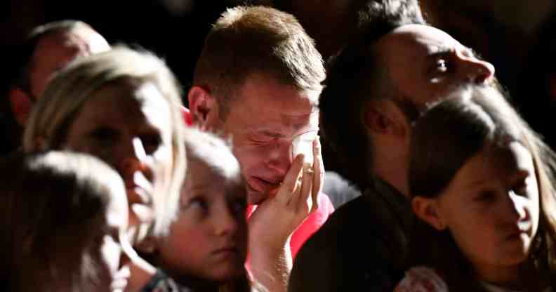 A scene from the vigil inside All Souls Unitarian Church in downtown Colorado Spring shows a man crying