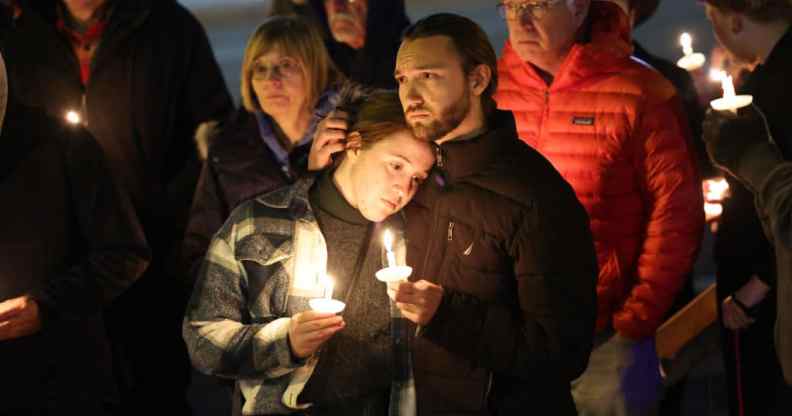 People hold a vigil at a makeshift memorial near the Club Q nightclub on November 20, 2022.