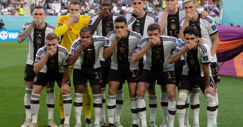 German football team members pose with their hands covering their mouths as they line up for the team photo ahead of the FIFA World Cup Qatar match between Germany and Japan