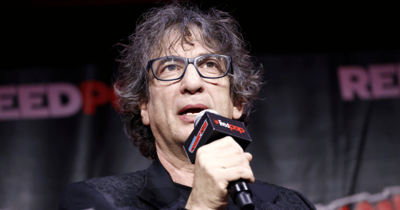 The Sandman creator Neil Gaiman speaks into a microphone at New York Comic Con 2022