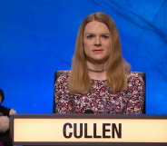 Emily Cullen appears on university challenge against a blue background, next to the team's teddy bear mascot