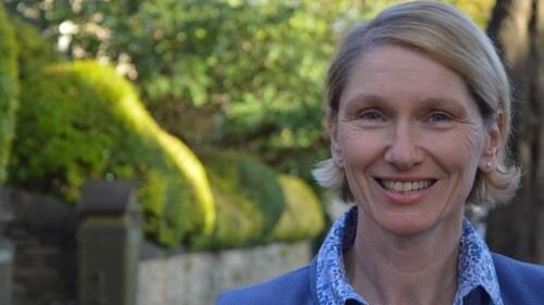 A photo showing Green Party election candidate Alison Teal smiling against a rural village background