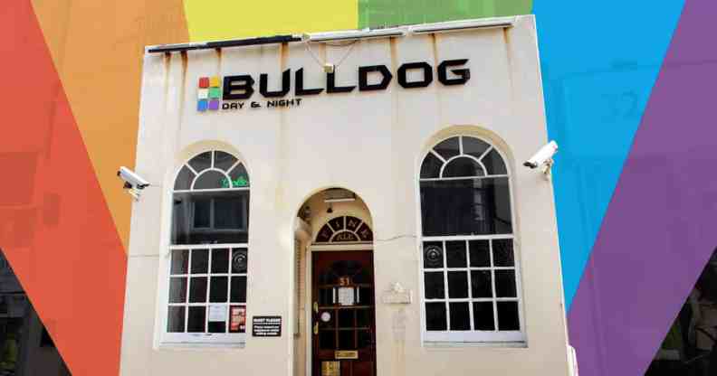 A small white building with Bulldog writte above the door. The picture has been cut out and placed on a rainbow background