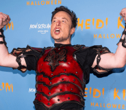 Elon Musk flexes while wearing a set of read armour during a Haloween christmas party.