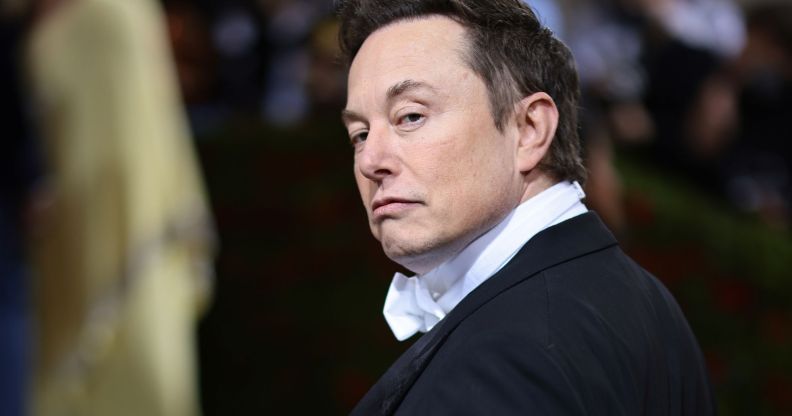 Elon Musk turns his head, eyebrow raised, giving a stern look to the camera.