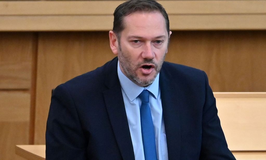 Conservative MSP Douglas Lumsden wears a suit and tie while speaking during a parliamentary proceeding in Holyrood