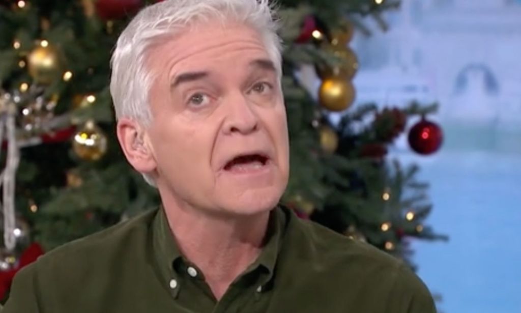 Phillip Schofield, who is wearing a green-brown shirt, talks to other people gathered for an episode of This Morning