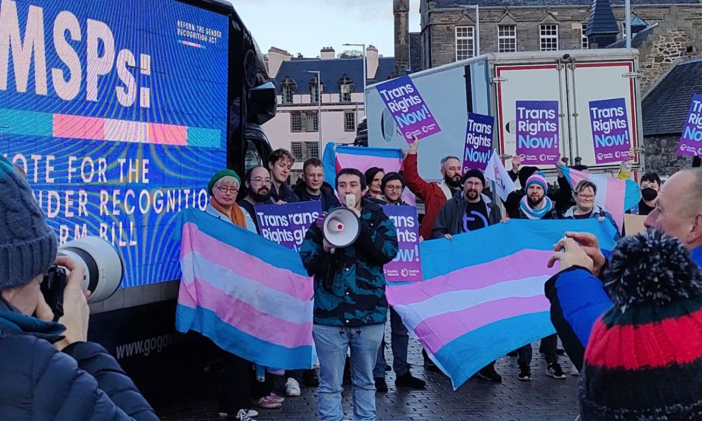 A group of people holding up the trans flags and signs in support of the trans community call on MSPs to pass the Gender Recognition Reform (Scotland) bill