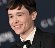 Elliot Page smiles at the camera while wearing a black and white tuxedo