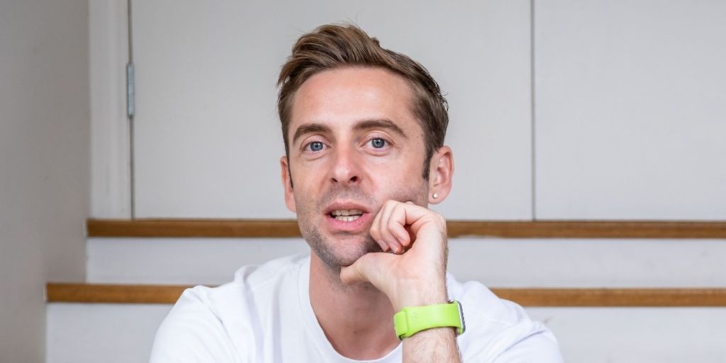 Author Daniel harding wearing white t-shirt resting his chin on his hands