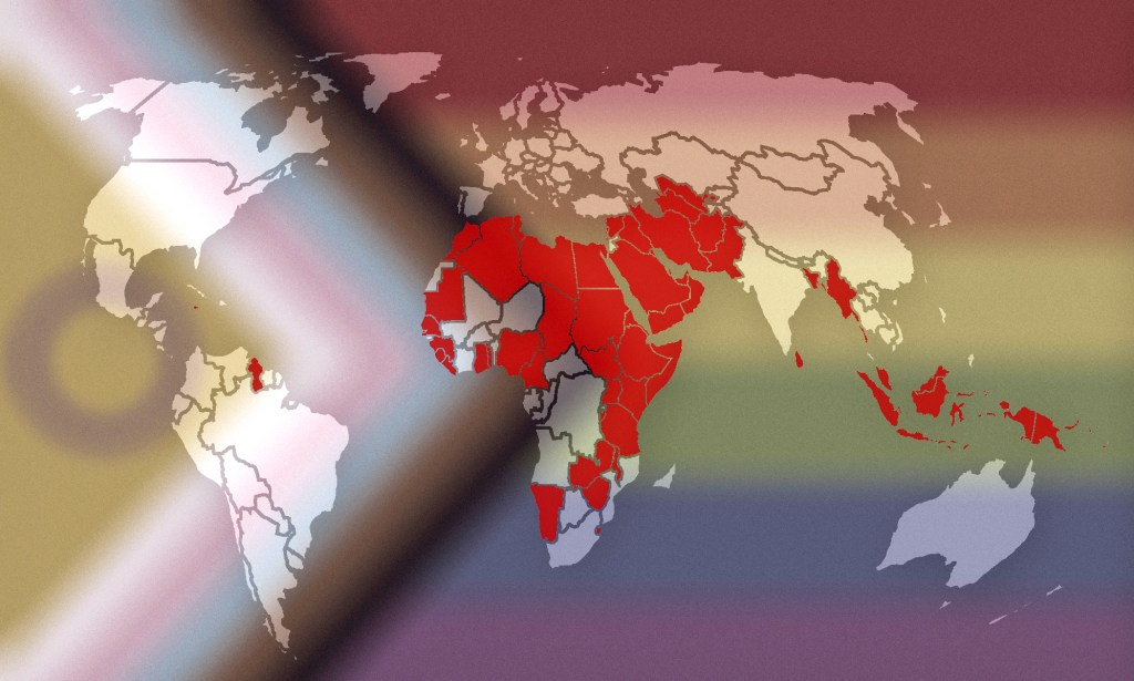 This image shows a map of the world, with countries and territories where LGBTQ+ people are criminalised are marked in red. The map is laid over the Progress Pride flag, which incorporates intersex identities, Black people and people of colour, and the entire LGBTQ+ community.