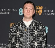 A photo of comedian Joe Lycett wearing a black and white patterned suit jacket over a white top at the Bafta awards ceremony. (Getty)