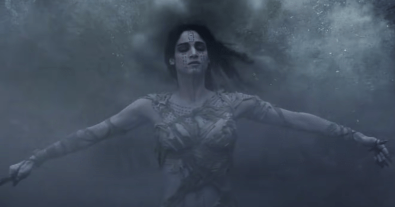 A still from The Mummy (2017) featuring the Mummy played by actress Sofia Boutella with her arms out and eyes closed while being covered in a mist