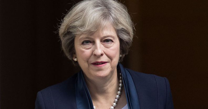 A photo shows former prime minister Theresa May wearing a navy suit leaving Westminster.