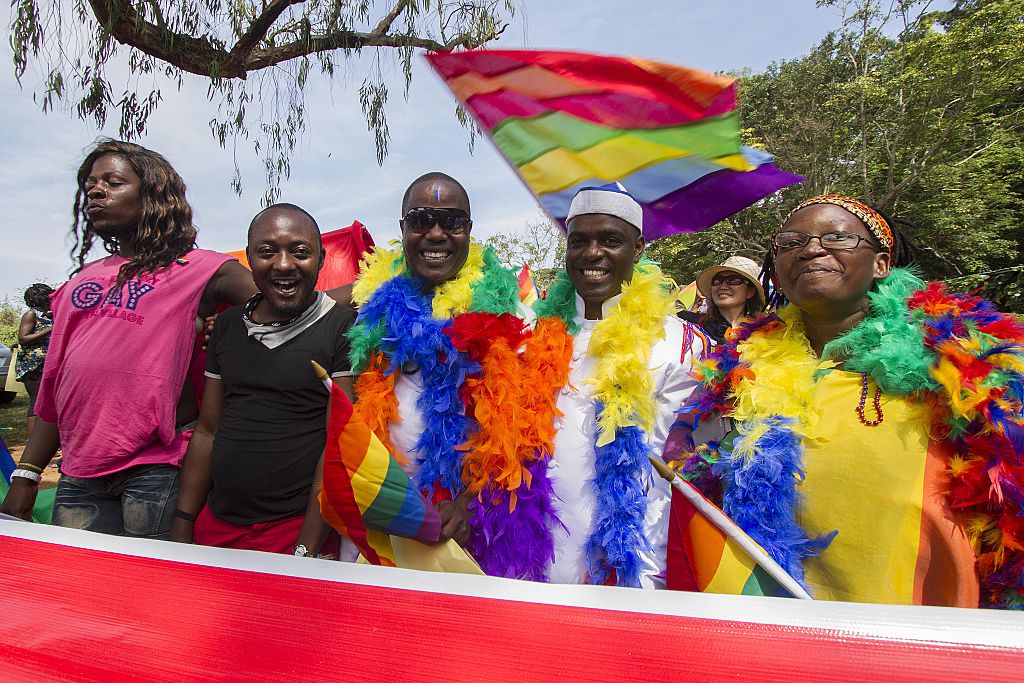 People hold rainbow flags as they take part in the Gay Pride parade in Entebbe on August 8, 2015.