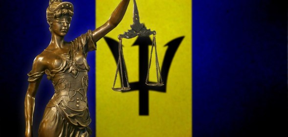 Lady Justice in front of the Barbados flag