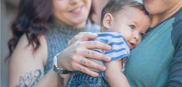 Two women holding a baby