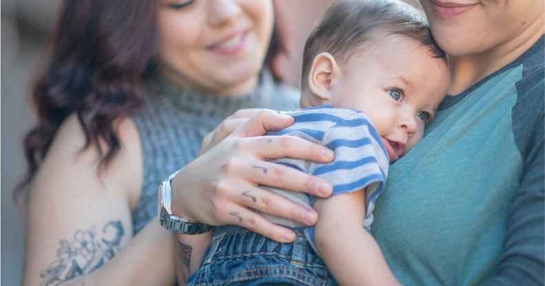 Two women holding a baby