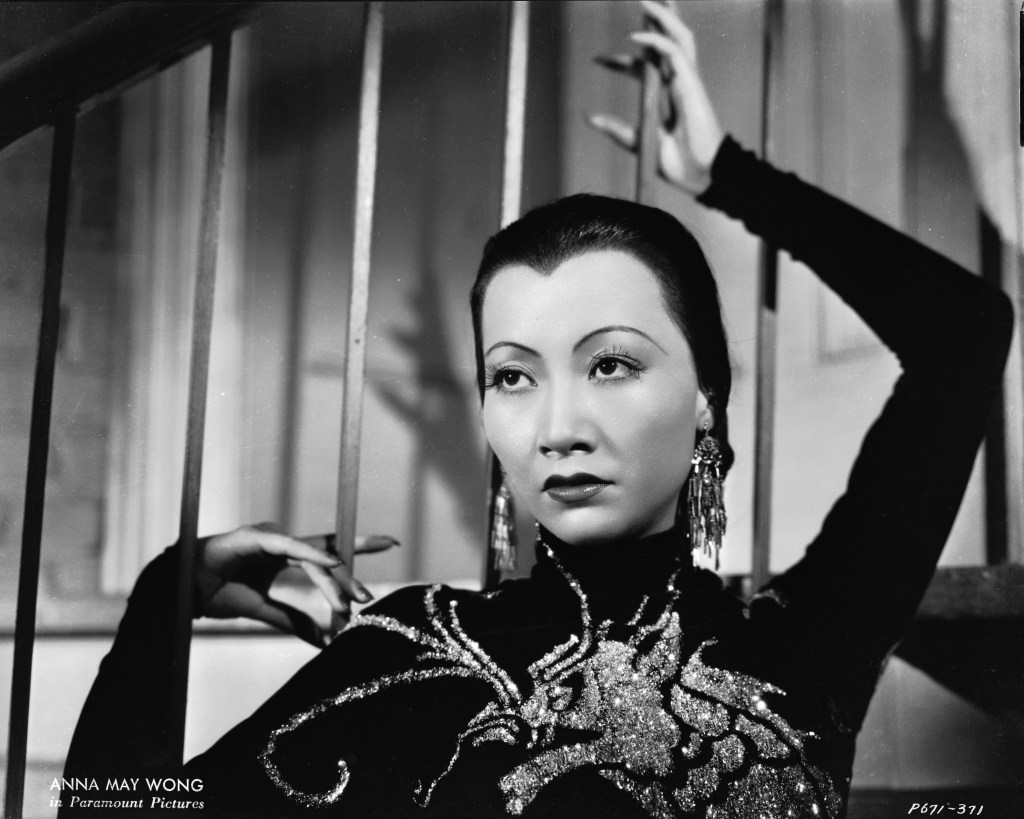 Anna May Wong wearing a dress with a dragon motif.