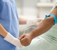 An individual donates blood in a hospital room.