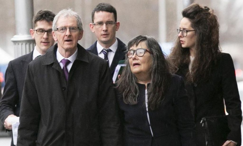 Members of Enoch Burke's family are seen walking with him in the rain.