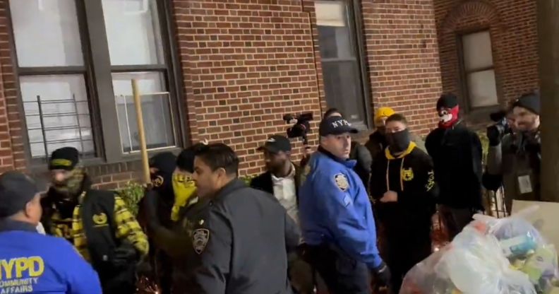 A group of Proud Boys members wearing masks are escorted by NYPD officers.