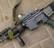 An image of an AR-15 lying down on a brick pavement.