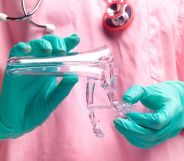 A doctor wearing a pink scrubs is holding equipment used in a cervix screening test