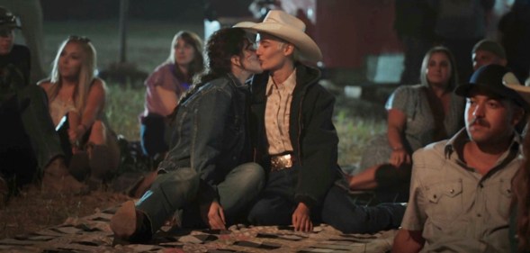 A still from Yellowstone showing actor Lilli Kay (L) as Clara kissing her real-life partnerJuli Kocemba during the series' midseason finale. (Paramount)