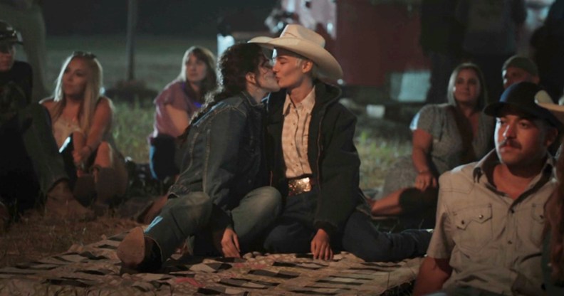 A still from Yellowstone showing actor Lilli Kay (L) as Clara kissing her real-life partnerJuli Kocemba during the series' midseason finale. (Paramount)