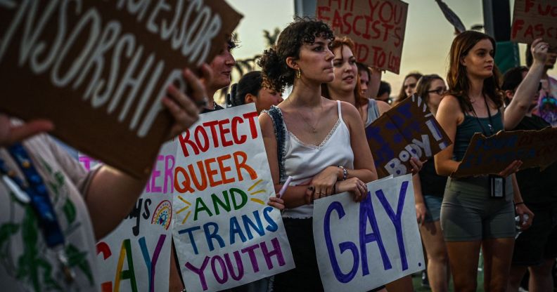 LGBTQ+ rights advocates gather around in protest of Ron DeSantis and the 'Don't Say Gay' bill in protest