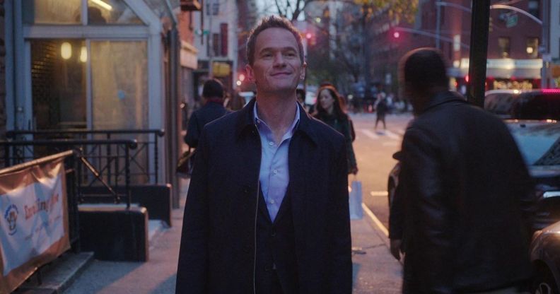 Neil Patrick Harris in Netflix series Uncoupled. The actor is shown in a still image walking down a street wearing a jacket as night falls.