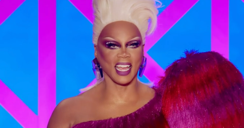 RuPaul judging Drag Race UK season 4 in a blonde wig and red and pink dress