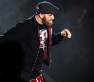 Sami Zayn walks down the ramp of a WWE show during a match.