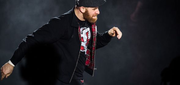 Sami Zayn walks down the ramp of a WWE show during a match.