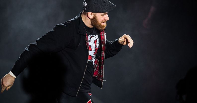 Sami Zayn walks down the ramp of a WWE show during a match.