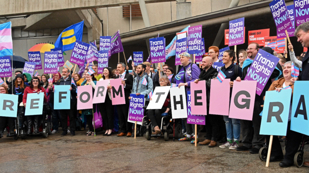 Protesters calling for GRA (gender recognition act) reform, holding signs reading "reform the GRA" outside Scottish parliament