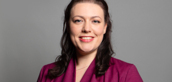 Alicia Kearns in a pink shirt and in front of a grey background